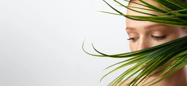 Portret van roodharig meisje poseren met groene plant, witte achtergrond — Stockfoto