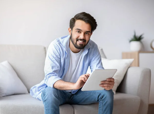 Hombre árabe joven guapo usando la computadora digital de la tableta en el país — Foto de Stock