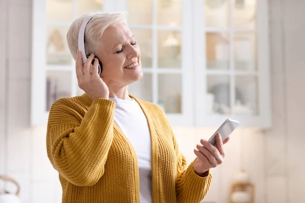 Alegre abuela divertirse, escuchar música en el teléfono — Foto de Stock