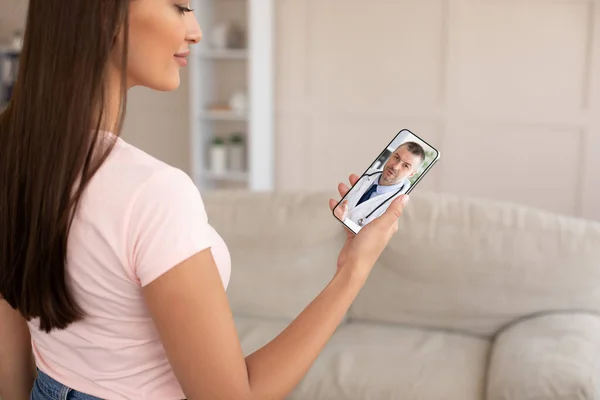 Young woman using smartphone at home, making video call with doctor — Stock Photo, Image