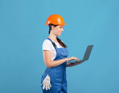 Güzel Genç Kadın Bakım İşçisi Laptop kullanıyor, İnşaat Malzemelerini Çevrimiçi Sipariş Ediyor