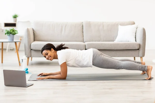 Zwarte vrouw oefenen thuis kijken tutorial op laptop — Stockfoto