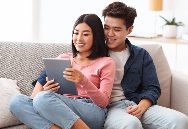 Chinees vriendje en vriendin met tablet kijken naar de film thuis — Stockfoto