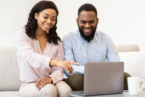 Afrikanisch-amerikanisches Paar sitzt auf Couch und benutzt Laptop — Stockfoto