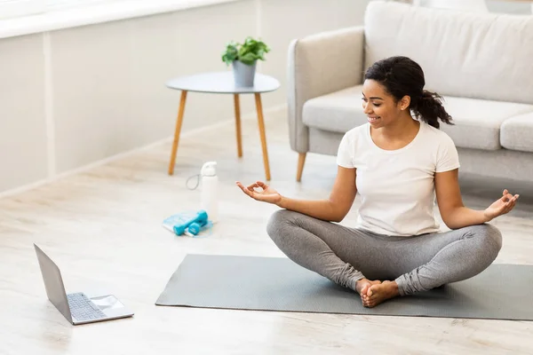 Černá žena cvičení jóga sledování online videa na notebooku — Stock fotografie