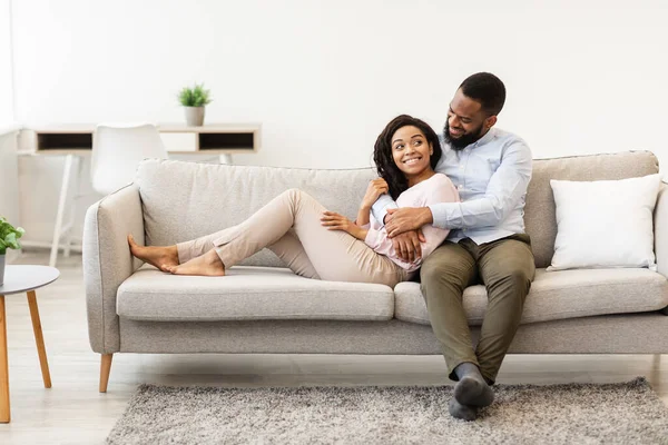 Africano casal americano passar fim de semana juntos deitado no sofá — Fotografia de Stock