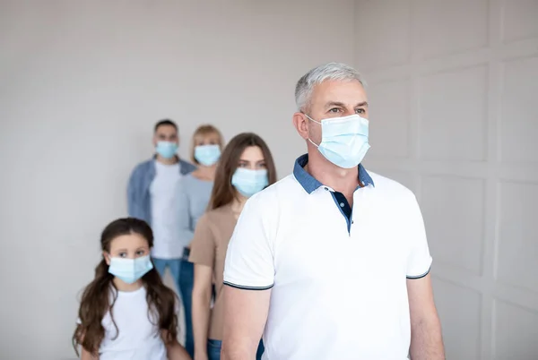 Senior man in protective mask waiting in queue for vaccine injection against coronavirus at clinic, blank space — Stock Photo, Image