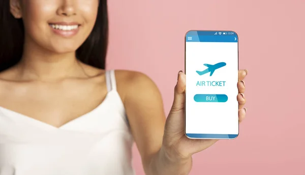 Woman Showing Smartphone With Flight Booking Application Over Pink Background