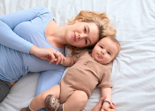 Ovanifrån av mor och barn som ligger på sängen — Stockfoto