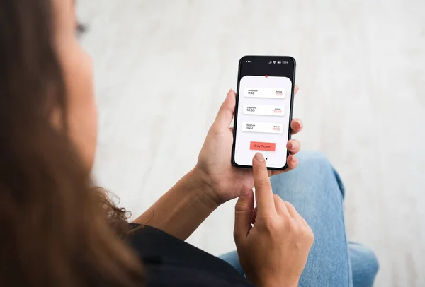 Senhora irreconhecível comprando ingressos usando aplicativo Smartphone sentado dentro de casa — Fotografia de Stock