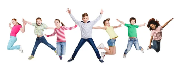 Alegre Multiracial Kids saltando en medio del aire posando sobre fondo blanco — Foto de Stock