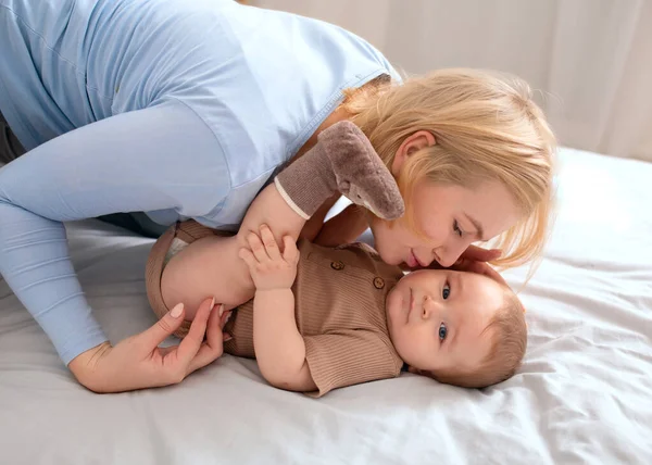 Beyaz tenli bir anne küçük bebeğini öpüyor. — Stok fotoğraf
