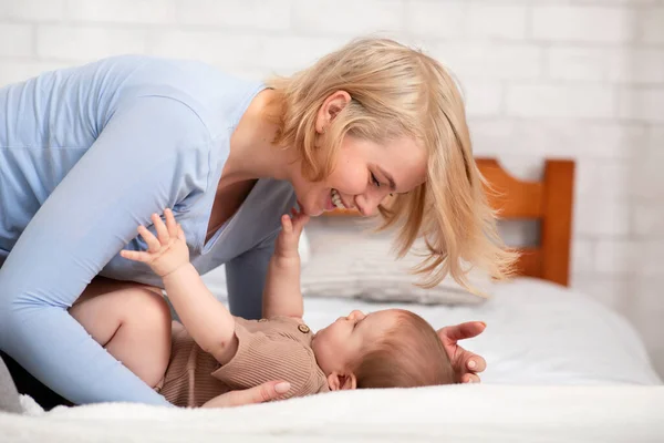 Mama iubitoare mângâindu-și copilul în pat — Fotografie, imagine de stoc