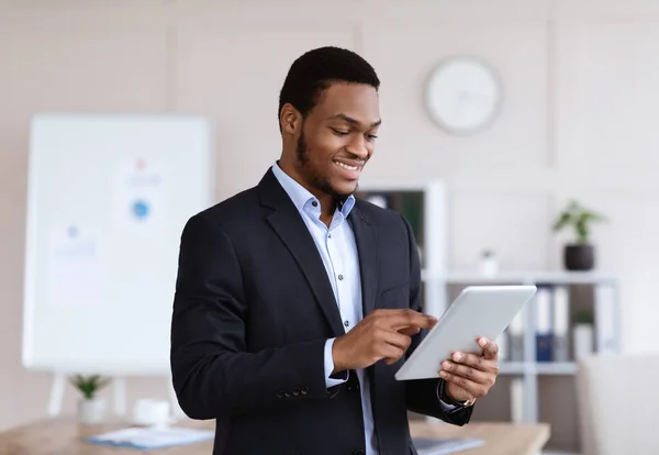 Usmívající se černý manažer pomocí digitálního tabletu, interiér kanceláře — Stock fotografie