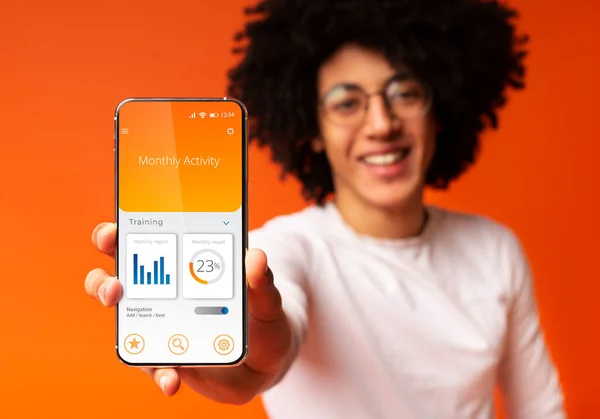 Man Showing Smartphone With Physical Activity Application Over Orange Background