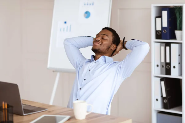 Gerente americano africano alegre descansando em sua cadeira — Fotografia de Stock