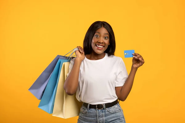 Glad svart dam med shoppingväskor och kreditkort — Stockfoto