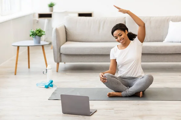 Μαύρη γυναίκα άσκηση στο σπίτι βλέποντας φροντιστήριο στο φορητό υπολογιστή — Φωτογραφία Αρχείου
