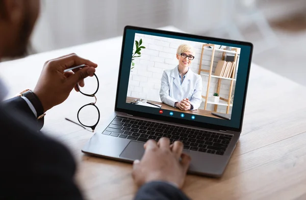 Hombre de negocios negro irreconocible que tiene videocall con socio de negocios en el ordenador portátil — Foto de Stock