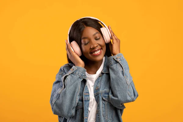 Χαρούμενη νεαρή μαύρη γυναίκα με κλειστά μάτια που ακούει μουσική — Φωτογραφία Αρχείου