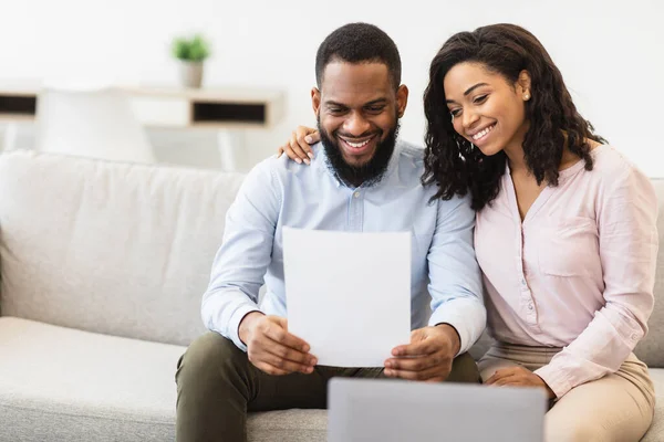 Lächelndes schwarzes Paar liest Dokumentation zu Hause, überprüft Vereinbarung — Stockfoto