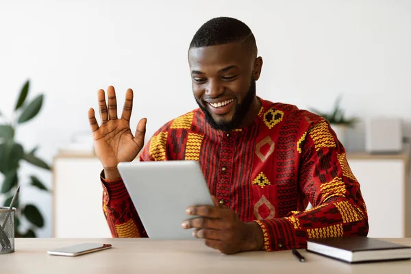 Chico negro alegre en camisa africana haciendo videollamada con tableta digital —  Fotos de Stock