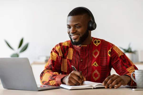 Afstandsonderwijs. Happy Black Millennial Guy Studeren Online met laptop en headset — Stockfoto