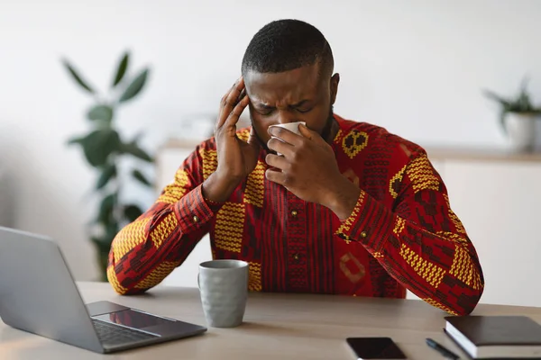 Kranker Afrikaner im traditionellen Hemd fühlt sich bei der Arbeit im Büro unwohl — Stockfoto