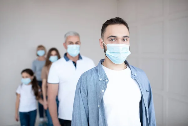 Un joven con máscara médica haciendo cola para vacunarse contra el coronavirus en el centro de salud, espacio vacío — Foto de Stock