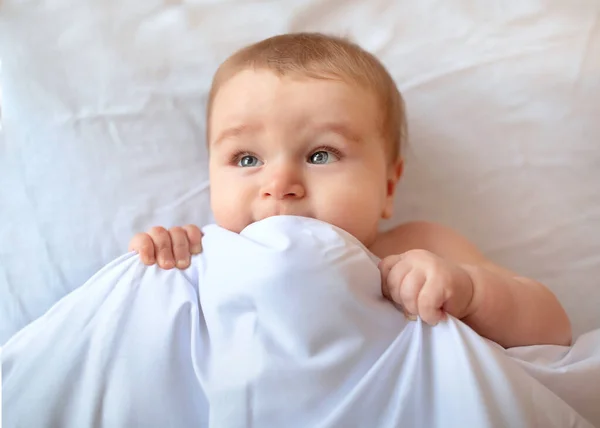 Yatakta battaniyenin altında sevimli bir bebek, yakın plan. — Stok fotoğraf