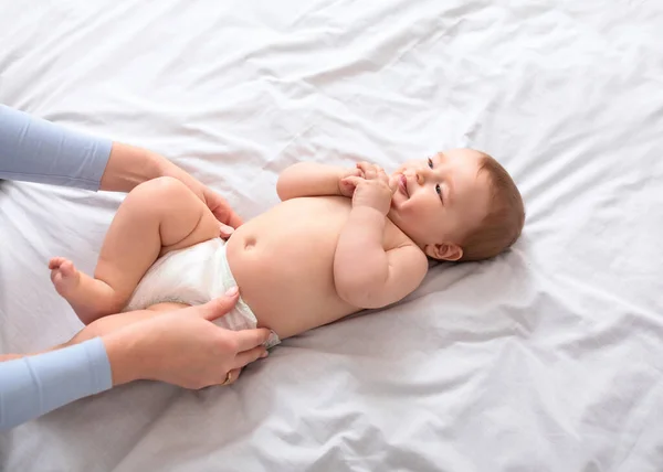 Madre cambiando pañales de bebé en blanco, vista superior —  Fotos de Stock