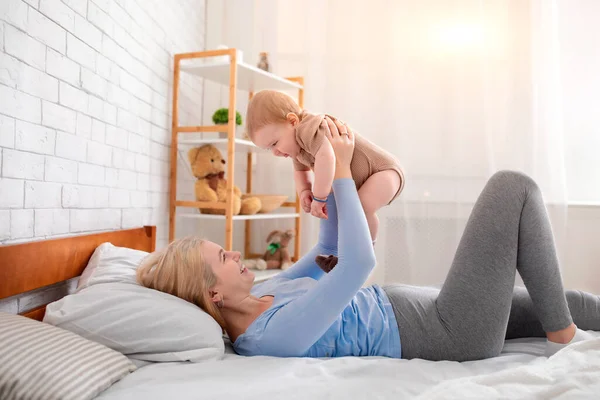 Happy jeune mère soulevant son mignon petit bébé vers le haut — Photo