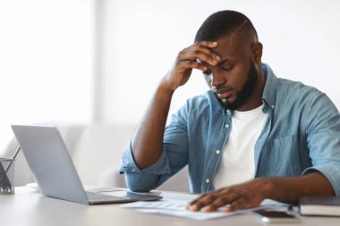 İş sorunları işte. Hüsrana uğramış Afrikalı Amerikalı İşadamı Ofiste Belgeleri Okuyor