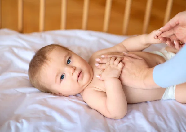 Matka masíruje její roztomilé malé dítě tělo — Stock fotografie