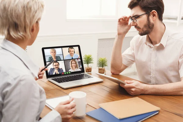 Empresário e empresária no laptop se comunicando com colegas de trabalho on-line no interior — Fotografia de Stock