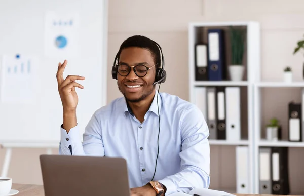 Jeune homme africain positif ayant une conférence d'affaires au bureau — Photo