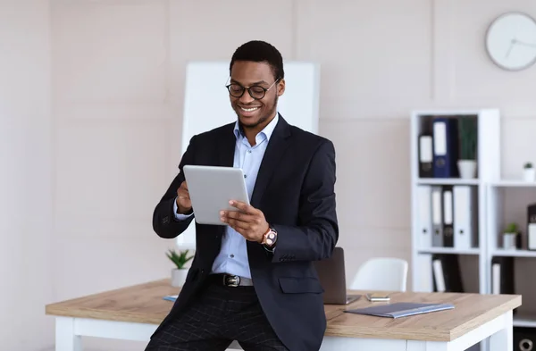 Neşeli Afrikalı Amerikalı iş adamı en yeni dijital tableti kullanıyor. — Stok fotoğraf