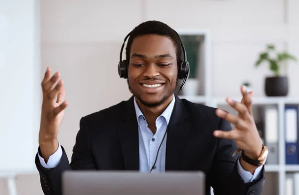 Primer plano del gerente inspirado con auriculares que tienen conferencia utilizando el ordenador portátil —  Fotos de Stock