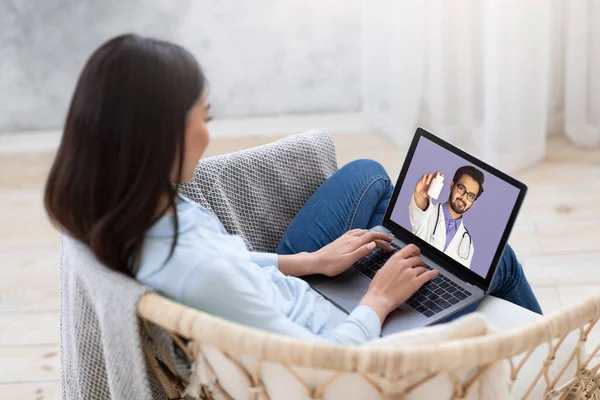 Ung kvinnlig patient som använder bärbar dator, prata med sin läkare om receptbelagd medicin online hemifrån — Stockfoto