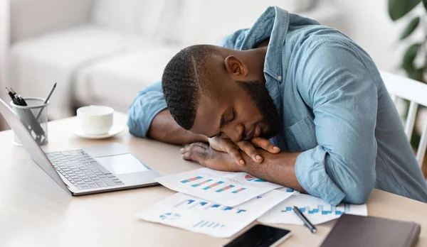 Slaap op het werk. Uitgeput zwart freelancer dutten aan bureau op kantoor thuis — Stockfoto