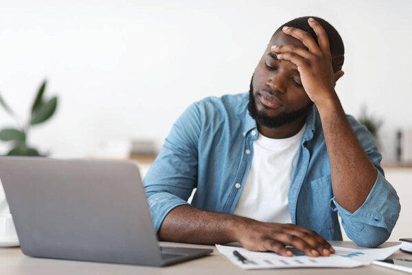Stressed Black Male Entrepreneur Having Problems At Work, Sitting Upset In Office