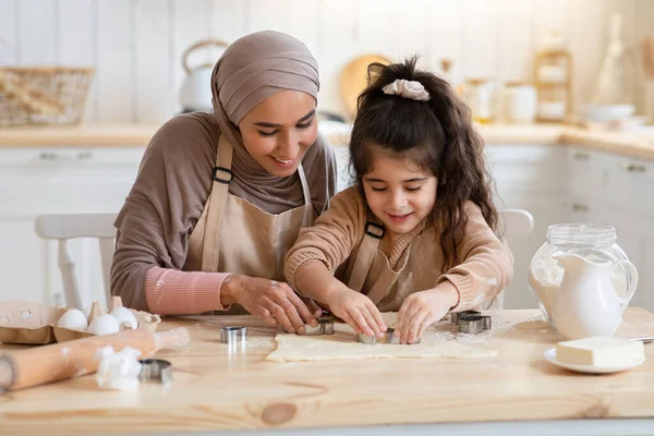 แม่มุสลิมที่เป็นบวกและลูกสาวของเธอ เตรียมคุ้กกี้ด้วยกันในครัว — ภาพถ่ายสต็อก