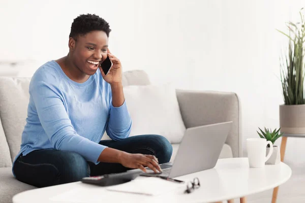 Senhora negra usando laptop chamando seu amigo, sentado no sofá — Fotografia de Stock