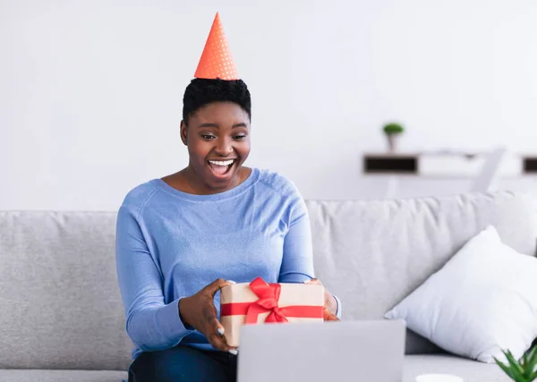 African American Woman Holding Present Box Using Laptop