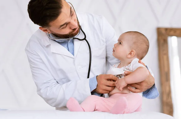 Médecin examinant bébé en bas âge avec stéthoscope écoutant des battements de coeur à l'hôpital — Photo