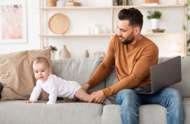 Babam evde dizüstü bilgisayarla bebek bakıcılığı yapıyor.