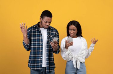 Bin yıllık üzgün Afro-Amerikan çifti telefonlarına bakıp ellerini kaldırıyor.