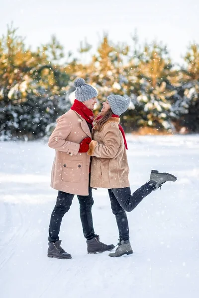 Mężczyzna i kobieta w miłości całują się nad białym zimowym lasem — Zdjęcie stockowe