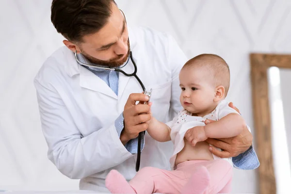 Médecin examinant le petit bébé écoutant les battements de coeur des enfants dans la clinique — Photo