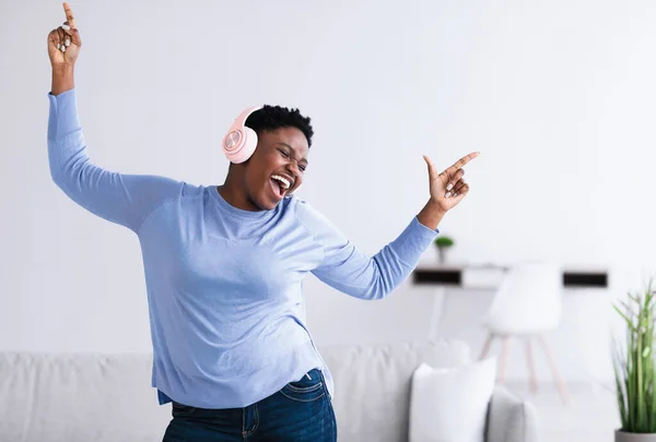 Mujer negra escuchando música en auriculares y bailando — Foto de Stock